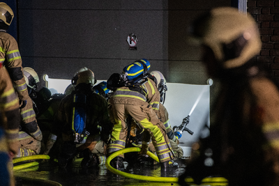 911070 Afbeelding van enkele brandweerlieden tijdens het blussen van de brand in het bedrijvenverzamelgebouw CAB-Rondom ...